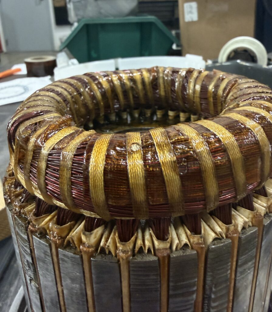 Stator end turns after varnish treatment, showing laced coils and slot insulation